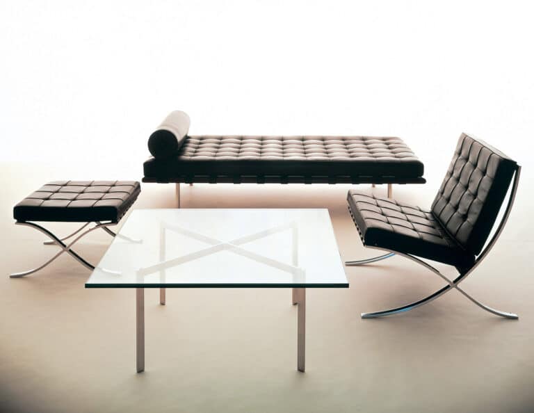 Mid-century modern black tufted leather lounge set with a glass coffee table and matching ottoman-style bench.
